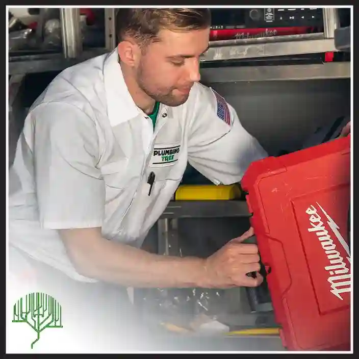 Plumbing Tree plumber retrieving a red Milwaukee tool bag from a service van